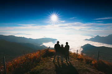 Asian family looking sunrise at top of the moutain, Thailand. Travel with family concept