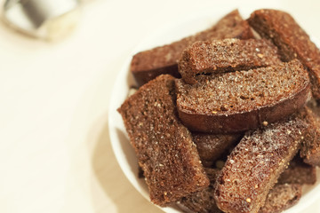 Fried garlic croutons, black bread on a white plate