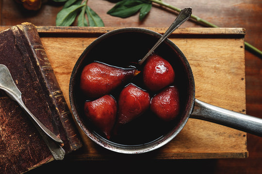 Pan of poached pears in a red wine sauce