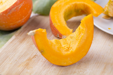 Closeup of pumpkin slices on a wooden table. 