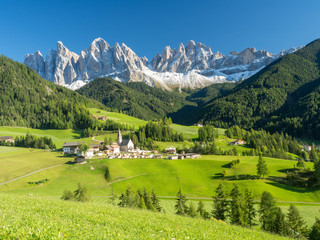 Colors of Dolomites. funes view of the valley, Puez-Odle in autumn. at sunset holy magdalena. View of odle mountain. Santa Maddalena, Tyrol, Italy. Green grass, mountains and blue sky. Summer - obrazy, fototapety, plakaty