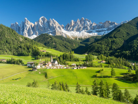 Colors of Dolomites. funes view of the valley, Puez-Odle in autumn. at sunset holy magdalena. View of odle mountain. Santa Maddalena, Tyrol, Italy. Green grass, mountains and blue sky. Summer