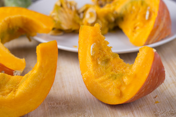     Pumpkin slices and seeds on the table. 
