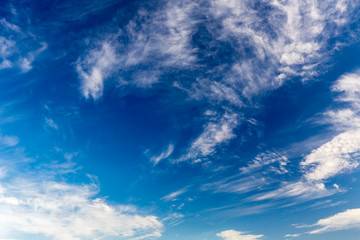 Airplane flies in white clouds in a blue sky and leaving trail