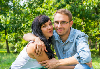 Obraz premium Loving couple - husband and wife - hugging in the park on a sunny day