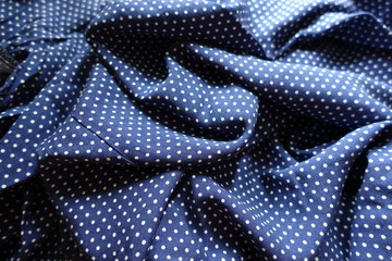 Wrinkled fabric in blue and white with polka dot print