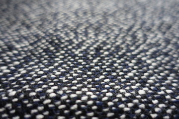 Close view of tweed fabric woven from black, white and blue threads