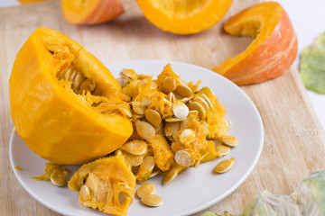     Pumpkin slices and seeds on the table. 
