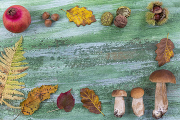 Decorative autumn border with chestnuts, walnuts, hazelnuts, acorns and leaves on wooden