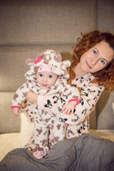 Portrait of a proud loving mother holding her newborn baby daughter at home. Portrait of a newborn baby infant toddler. Close up top view portrait infant baby.