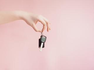 asian woman give her  car key to new car owner by beauty hand with pink pastel background , sale or rent car concept