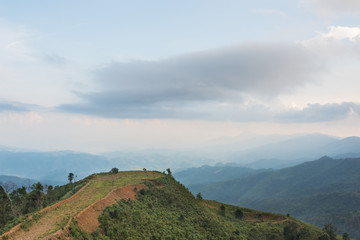 Naklejka premium Scenery with mountain peaks and cloud mist on sky at Phou Khoun in Laos. evening time
