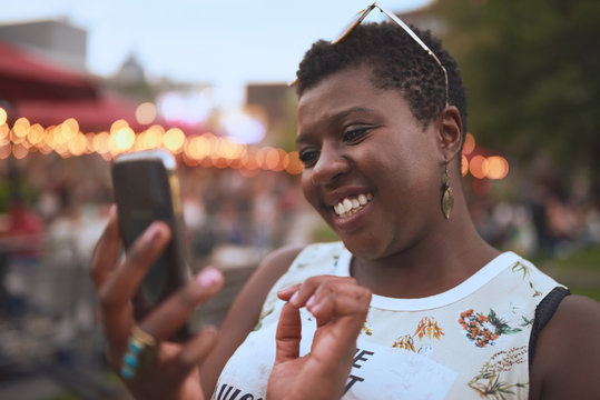 Authentic Young African American Woman Using A Mobile Phone At A Summer Music Festival