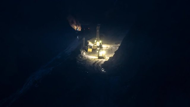 Time lapse of open pit mining at night. Zoom in effect