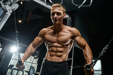 Fototapeta na wymiar Brutal Caucasian bodybuilder training chest in gym