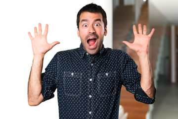 Naklejka premium Brunette man making surprise gesture inside house