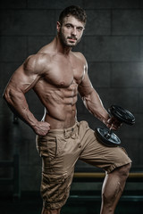 Obraz na płótnie Canvas Attractive model young man training in gym