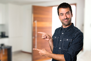 Brunette man pointing to the lateral inside house