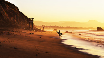 Fototapeta na wymiar Surfer on the beach at sunset
