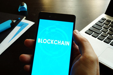 Man holding smart phone  with Blockchain.