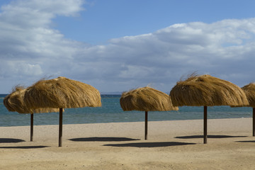 The rows of straw umbrellas on a deserted beach. El Gouna. Egypt.