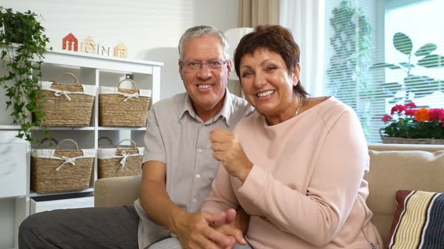 An Elderly Couple Communicates with Their Children using Laptop Video Call in the living room. Clow Motion