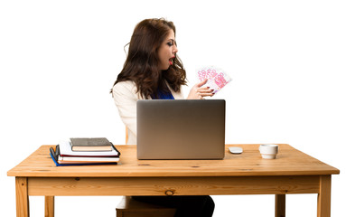 Business woman working with her laptop and taking a lot of money