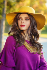 Young beautiful women in a yellow hat, outdoor