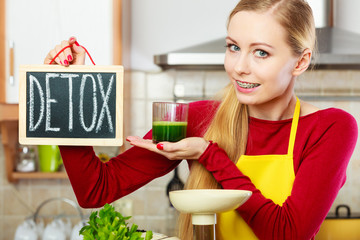 Woman in kitchen having green detox vegetables