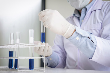 Scientist or medical in lab coat holding test tube with reagent, Laboratory glassware containing chemical liquid, Biochemistry laboratory research