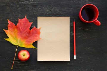 Autumn maple leaf, apple, cup of tea, paper for text and pencil