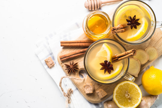Hot Ginger tea with lemon, honey and spices. Top view with copy space on white.