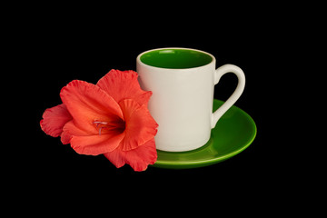 White cup and gladioli flower lying on the saucer