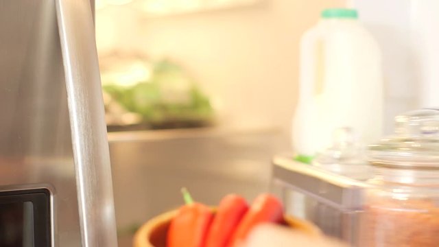 Young Man In A Checked Shirt Opening The Fridge Door