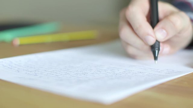 Shallow Depth of field hands writing an exam or college essay