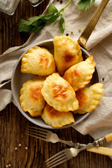 Baked dumplings stuffed with curd cheese and potatoes in a pan, top view