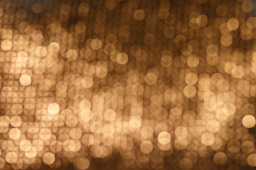 Abstract golden background. Abstract golden bokeh background, festive theme. Golden abstract sparkles or glitter lights. Festive gold background. Defocused circles bokeh or particles. Template for des
