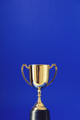 Gold winners trophy cup on a blue background