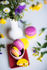 Macaroons and pink flowers tulips on white rustic wooden table with place for text. Present on Mothers day, Valentines Day or Womens day. Gritings woman concept. Copy space.