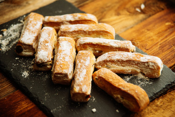 Strudel Apple and sugar powder. Biscuit from the puffed Test on the Gray Background. Dessert with Fruits.Copy space for Text. selective focus.