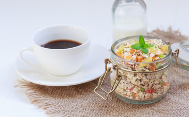 Traditional breakfast. Freshly brewed coffee, granola in a jar with mint, coffee pot, cup, dried fruits, candied fruits