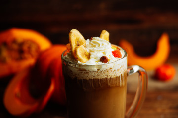 Pumpkin smoothie, spice latte. Boozy cocktail with whipped cream on top on a wooden background. Copy space Top view