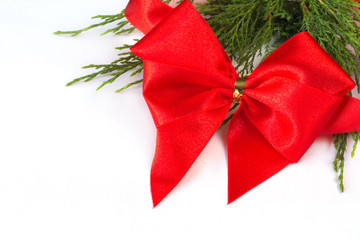 Christmas decoration red bow on a spruce branch on a white background with copy space top view