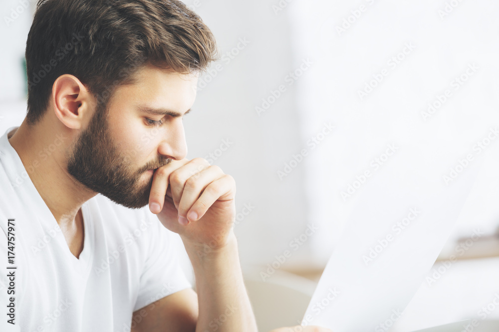 Wall mural attractive man examining document side