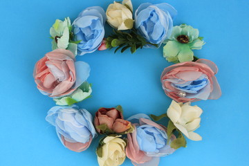This is a wreath of artificial colors on a blue surface