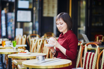 Woman drinking coffee in Parisian outdoor cafe