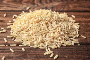 Heap of brown rice on wooden background