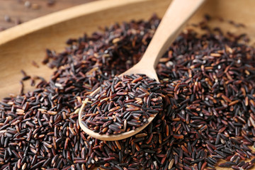 Plate and spoon with raw wild rice, closeup