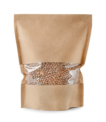 Paper package with brown lentils on white background