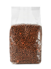 Plastic package with brown lentils on white background
